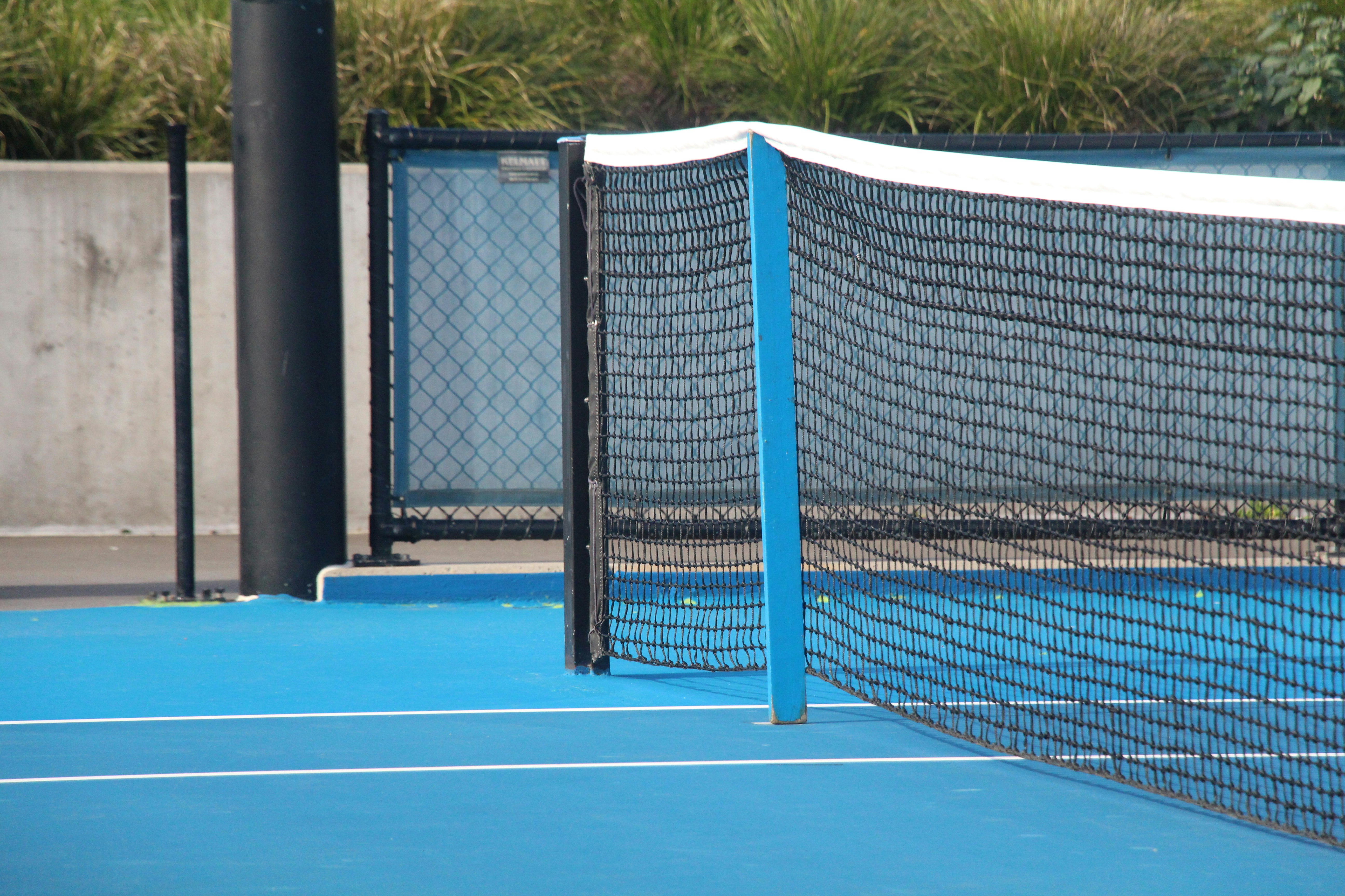 black metal fence on blue and white basketball court